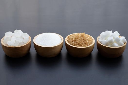 Various types of sugar on dark background.