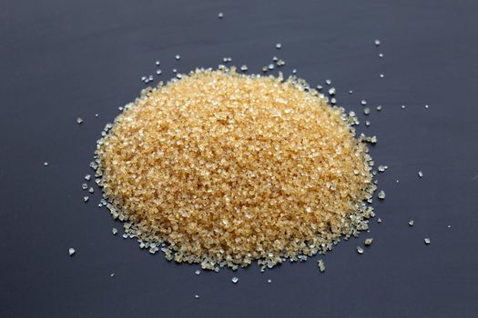 Brown sugar on dark background. Copy space