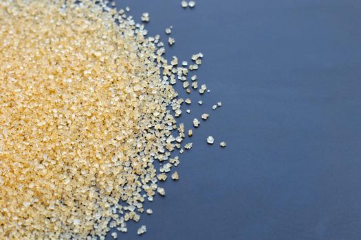Brown sugar on dark background. Copy space