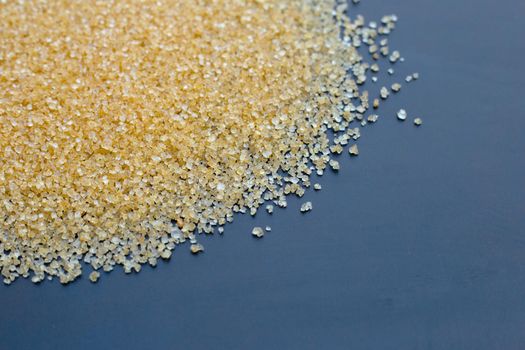 Brown sugar on dark background. Copy space