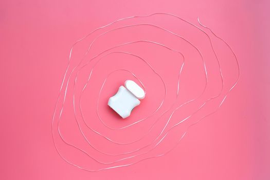 Dental floss on pink background. 