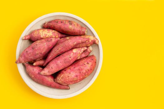 Sweet potato on yellow background. Top view