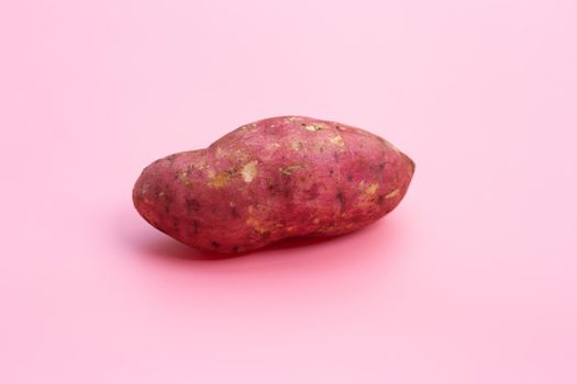 Sweet potato on pink background. 