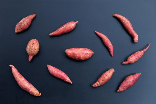 Sweet potato on dark background. Top view