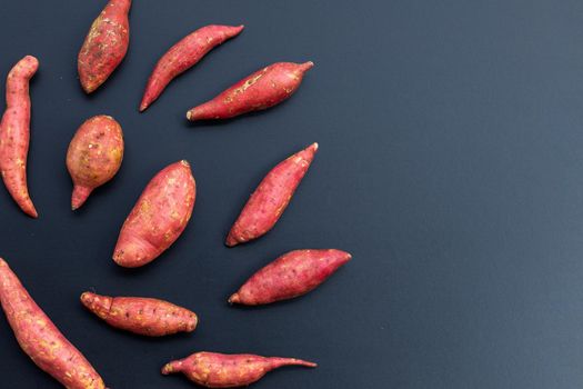 Sweet potato on dark background. Top view