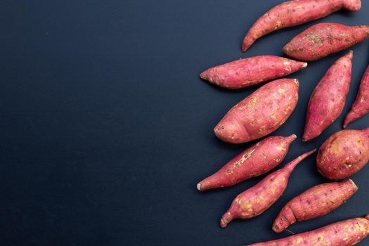 Sweet potato on dark background. Top view