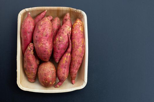 Sweet potato on dark background. Top view