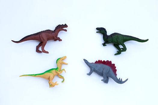 Plastic dinosaur toys on white background. Top view