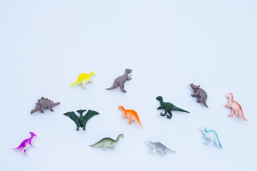 Plastic dinosaur toys on white background. Top view
