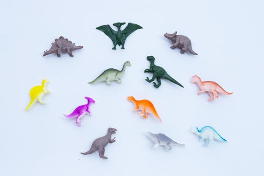 Plastic dinosaur toys on white background. Top view