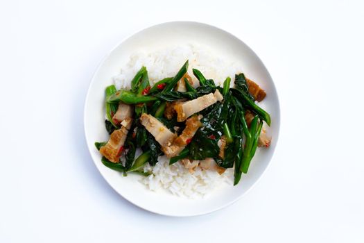 Stir fried chinese kale with crispy pork belly with rice on white