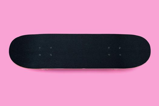 Black skateboard on pink background.
