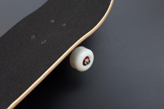 Black skateboard on dark background.