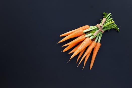 Fresh carrots on dark background.