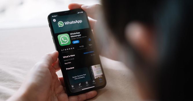 CHIANG MAI, THAILAND - APR 18, 2020 : Woman holding a iPhone and open appstore searching social Internet service WhatsApp on the screen.