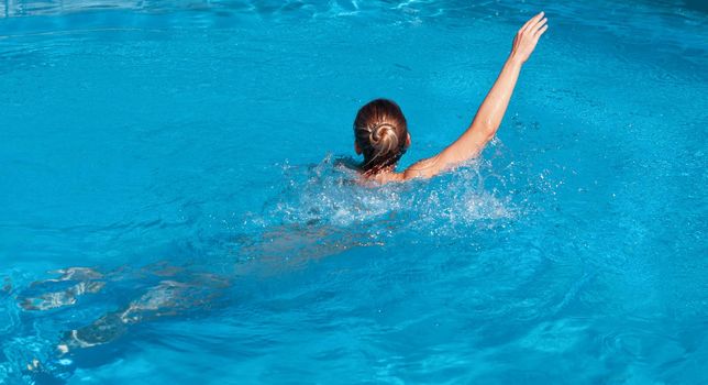 Naked woman outdoors. Beautiful young nude woman in swimming pool. Young nude blonde swims in the outdoor pool