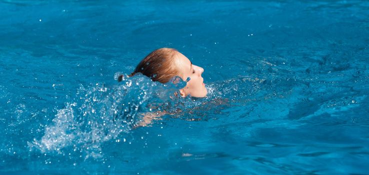 Naked woman outdoors. Beautiful young nude woman in swimming pool. Young nude blonde swims in the outdoor pool