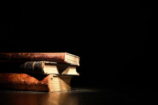 Stack of old books on dark background