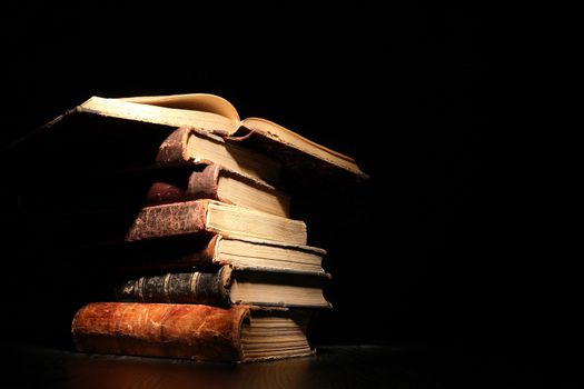 Stack of old books on dark background