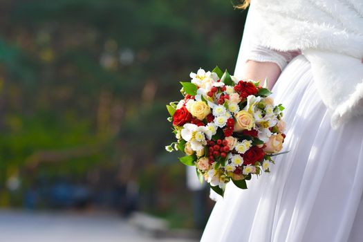 Wedding bouquet of flowers in the hands of a full bride.