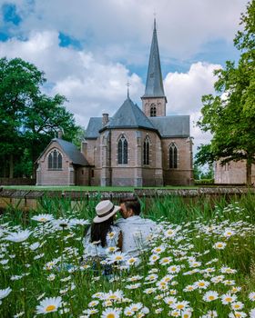 Castle de Haar Utrecht, couple men and woman mid age European and Asian visit De Haar Castle in Dutch Kasteel de Haar is located in Utrecht Netherlands during Spring with flowers in the garden