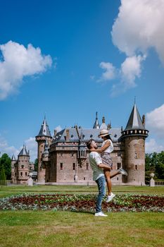 Castle de Haar Utrecht, couple men and woman mid age European and Asian visit De Haar Castle in Dutch Kasteel de Haar is located in Utrecht Netherlands during Spring with flowers in the garden