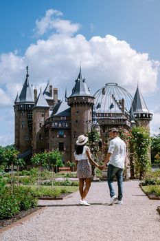 Castle de Haar Utrecht, couple men and woman mid age European and Asian visit De Haar Castle in Dutch Kasteel de Haar is located in Utrecht Netherlands during Spring with flowers in the garden