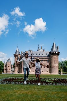 Castle de Haar Utrecht, couple men and woman mid age European and Asian visit De Haar Castle in Dutch Kasteel de Haar is located in Utrecht Netherlands during Spring with flowers in the garden