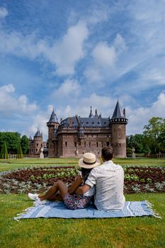 Castle de Haar Utrecht, couple men and woman mid age European and Asian visit De Haar Castle in Dutch Kasteel de Haar is located in Utrecht Netherlands during Spring with flowers in the garden