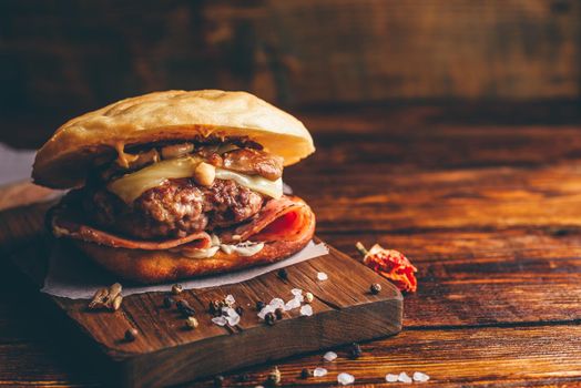 Homemade Cheeseburger with Beef Patty on Wooden Background and Copy Space.