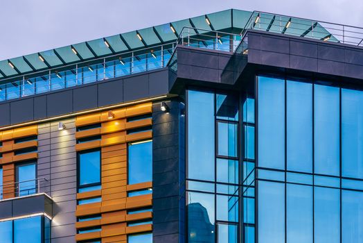 Modern high-rise office building with a glass facade at overcast, background.