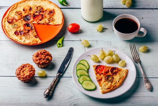 Healthy breakfast with frittata, fruits, vegetables, milk, cup of coffee and muffins on light wooden background.