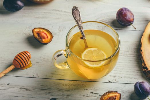 Cup of tea with lemon, honey and ginger over wooden surface