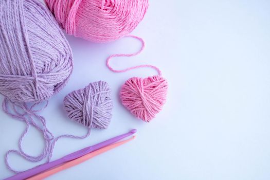 Threads,hooks, and two hearts lay on a white background.Holiday card, background. The concept of Valentine's Day, March 8, Mother's Day. Space for your text.