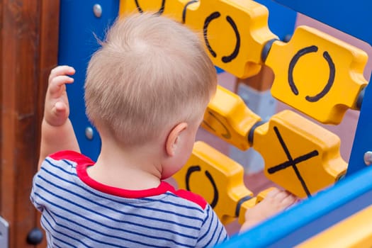 A little boy enthusiastically plays on the playground. Success, creative ideas and sports concepts. Children's playground. Games.