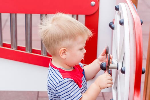 A little boy enthusiastically plays on the playground. Success, creative ideas and sports concepts. Children's playground. Games.