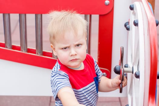 A little boy enthusiastically plays on the playground. Success, creative ideas and sports concepts. Children's playground. Games