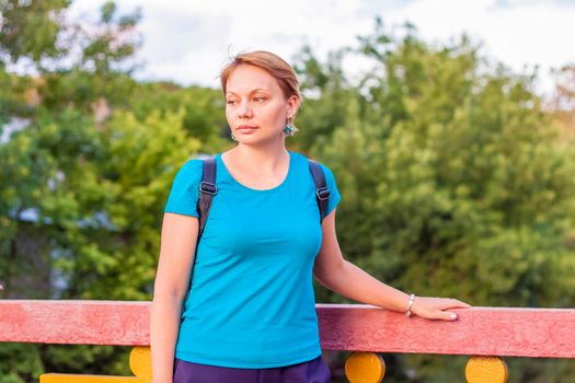 Portrait of a young girl. A girl in a blue T-shirt is standing on the street. The expression on his face. Portrait 