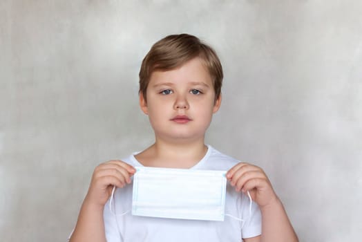 A boy in a medical mask. Coronavirus, disease, infection, quarantine, medical mask, COVID-19. Quarantine and protection from influenza viruses and epidemics covid-19. Coronavirus quarantine. 