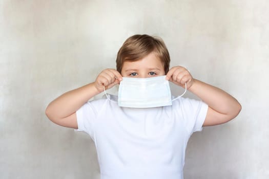 A boy in a medical mask. Coronavirus, disease, infection, quarantine, medical mask, COVID-19. Quarantine and protection from influenza viruses and epidemics covid-19. Coronavirus quarantine. 