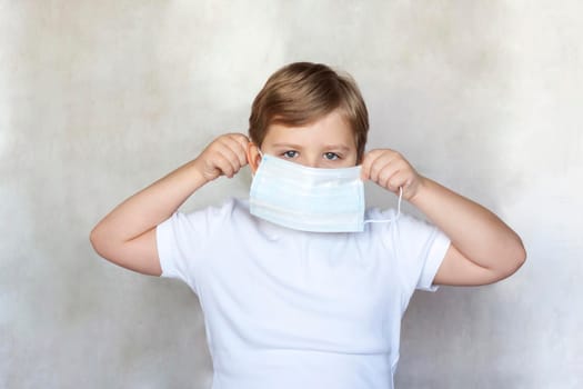 A boy in a medical mask. Coronavirus, disease, infection, quarantine, medical mask, COVID-19. Quarantine and protection from influenza viruses and epidemics covid-19. Coronavirus quarantine. 