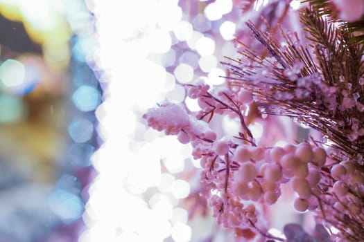 Christmas and New Year holiday background. Close-up of a Christmas tree in the snow against a background of bright lights. Snow