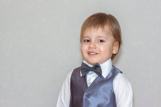 The concept of the Valentine's Day theme. Portrait of a cute boy in a suit with a bow tie. Valentine's Day.