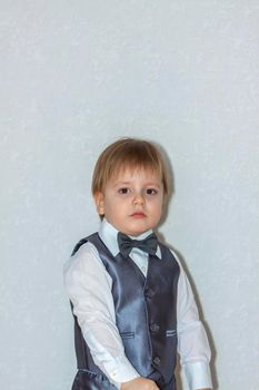 The concept of the Valentine's Day theme. Portrait of a cute boy in a suit with a bow tie. Valentine's Day.