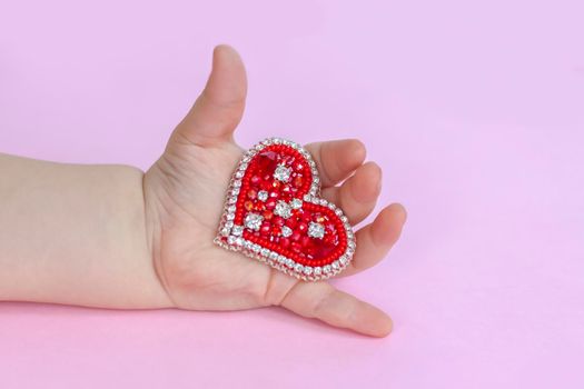 Red heart on the palm of your hand. The concept of the Valentine's Day theme. A greeting card, a declaration of love. February 14 