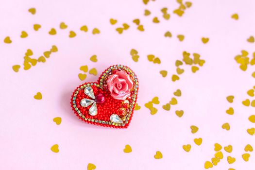 Pink background with gold hearts, sequins. Red heart made of beads. The concept of the Valentine's Day theme. Postcard, template, background for graphic works. The concept of the Valentine's Day theme. February 14 