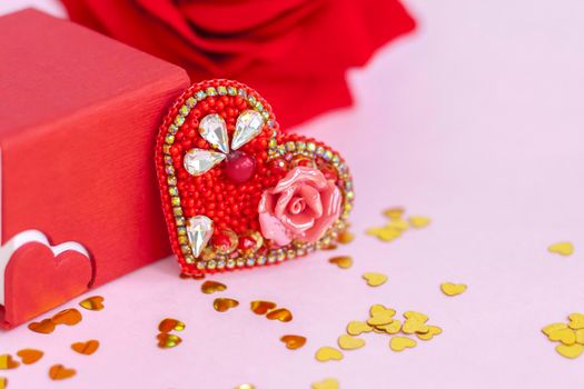 Pink background with gold hearts, sequins. Red heart made of beads. The concept of the Valentine's Day theme. Postcard, template, background for graphic works. The concept of the Valentine's Day theme. February 14