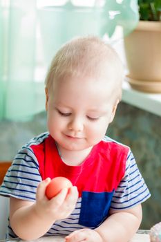 Portrait of a cute child with Easter eggs. Easter lunch. The feast of Holy Easter. Painted Easter eggs.