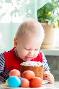 Portrait of a cute child with Easter eggs. Easter lunch. The feast of Holy Easter. Painted Easter eggs.