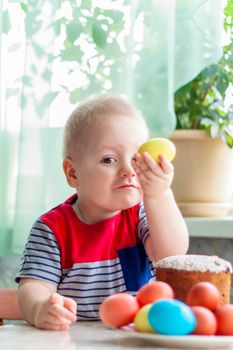 Portrait of a cute child with Easter eggs. Easter lunch. The feast of Holy Easter. Painted Easter eggs.